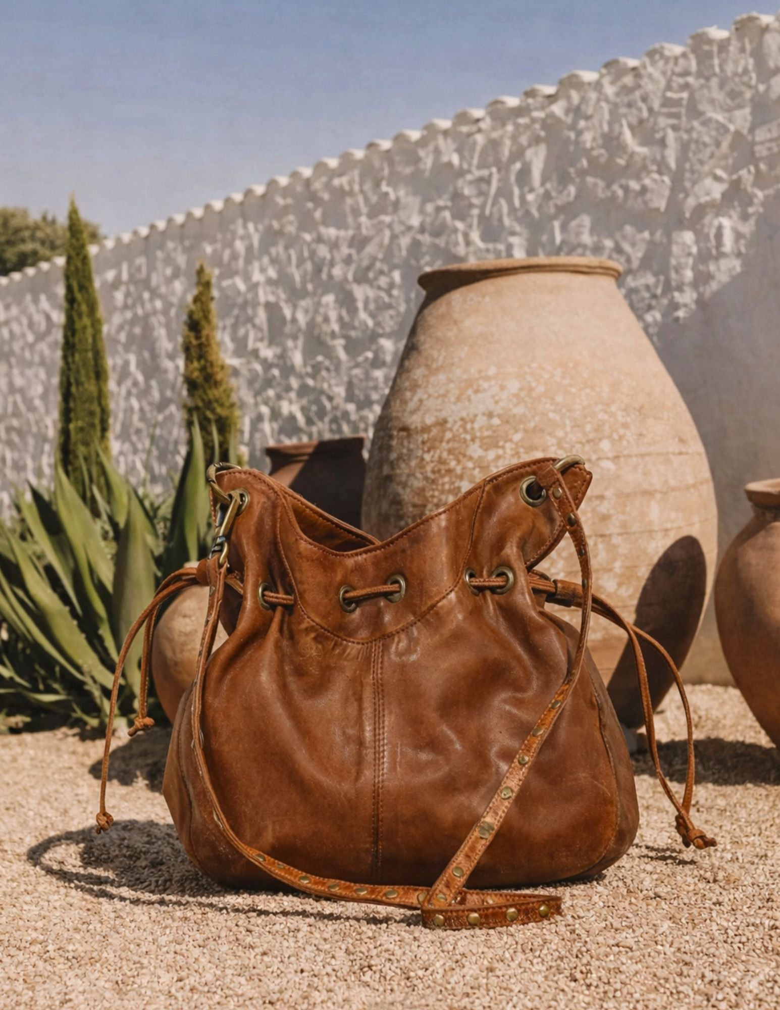 Brown leather bag on a textured surface with a scenic background